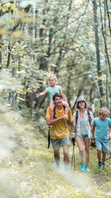 Famille qui marche en montagne, randonnée dans un cadre forestier