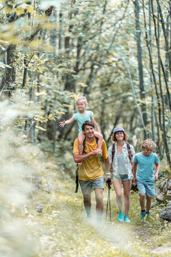 Famille qui marche en montagne, randonnée dans un cadre forestier
