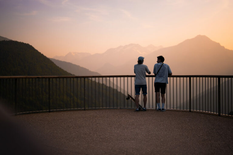 2 personnes contemplant le coucher de soleil sur le belvédère de la place de la Fare à Vaujany