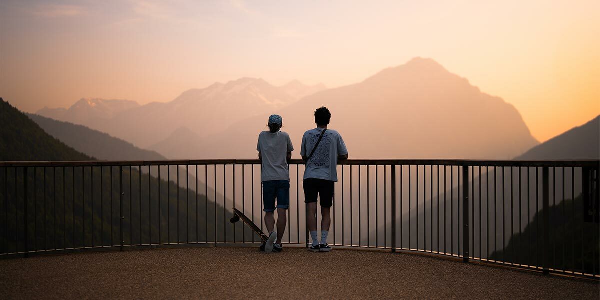 2 personnes contemplant un coucher de soleil au belevedère de Vaujany