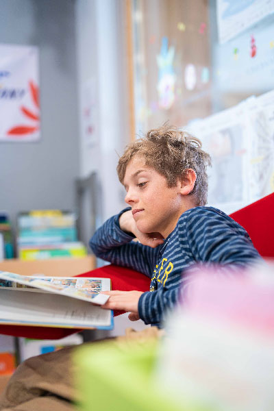 Enfant à la médiathèque lisant son livre