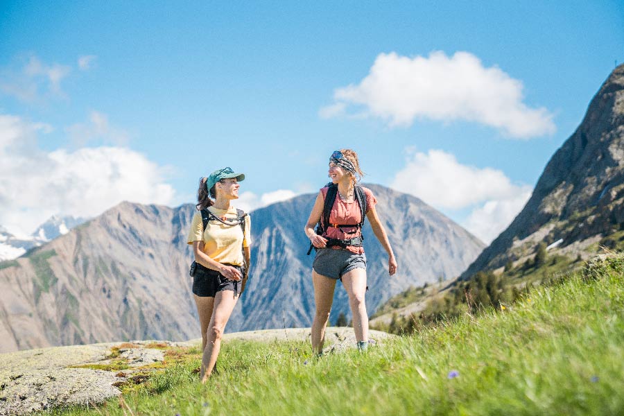 Deux randonneuses marchant en montagne avec panorama sur les Aiguillettes