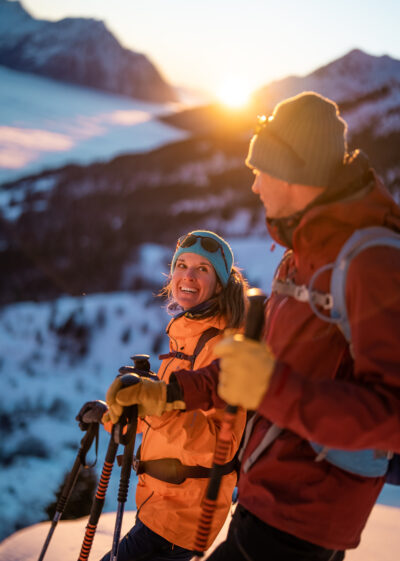 Couple appréciant les derniers rayons de soleil de leur descente à ski
