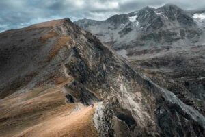 Randonneurs sur une crête aux couleurs d'automne avec vue sur les sommets alpins