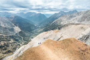 Randonneurs sur une crête aux couleurs d'automne avec panorama des Aiguillettes sur les vallées de l'Oisans