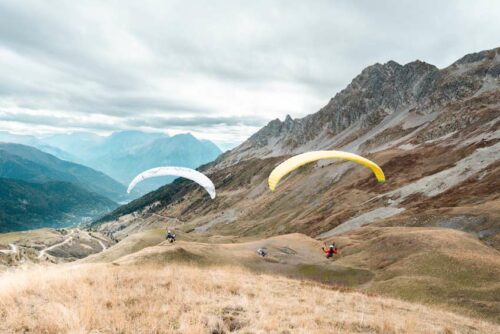 Envol de deux parapentistes dans les alpages de Vaujany aux couleurs d'automne
