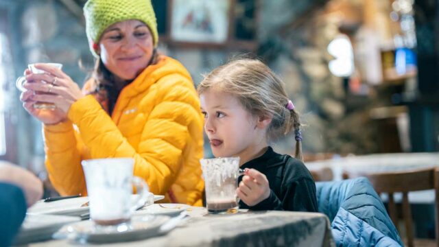Après ski : jeune fille attablée dégustant un chocolat chaud