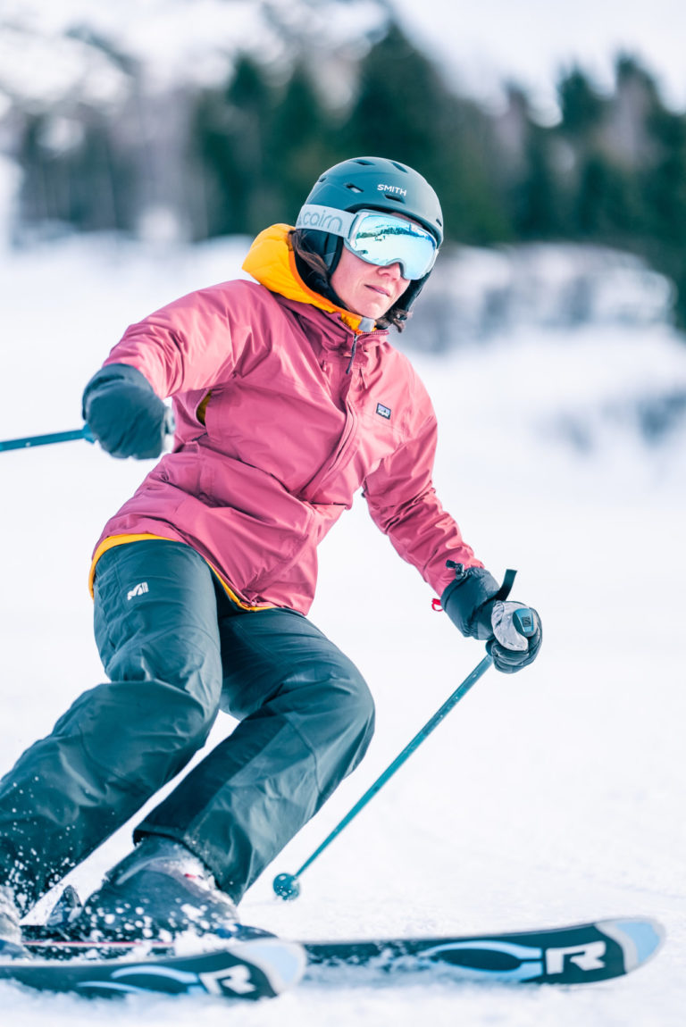 Skieuse avec veste tons rose teinte claire en conduire dérapée
