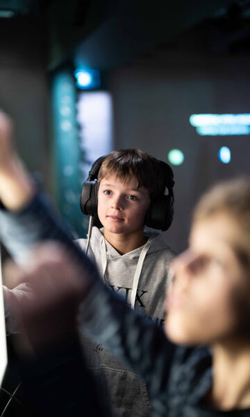 Enfants au musée de Vaujany en immersion sonore avec casque audio sur les oreilles