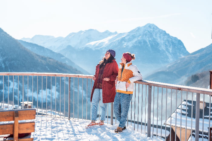 Maman et sa fille marchant avec des paniers sur une pente montagneuse aux couleurs d'automne dans une douce lumière